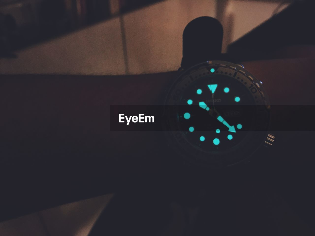 Cropped image of hand wearing glowing wristwatch