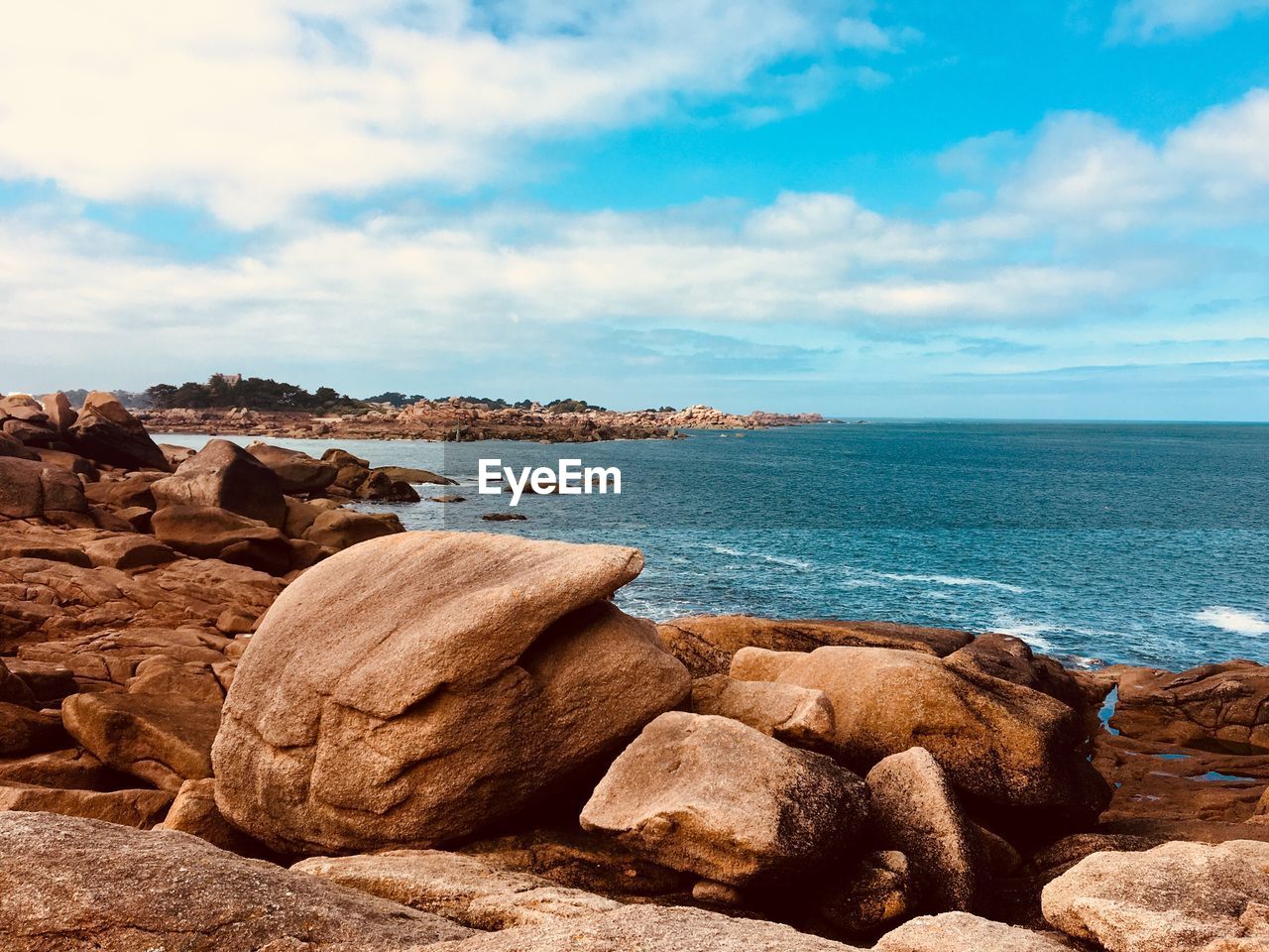 Rocks by sea against sky