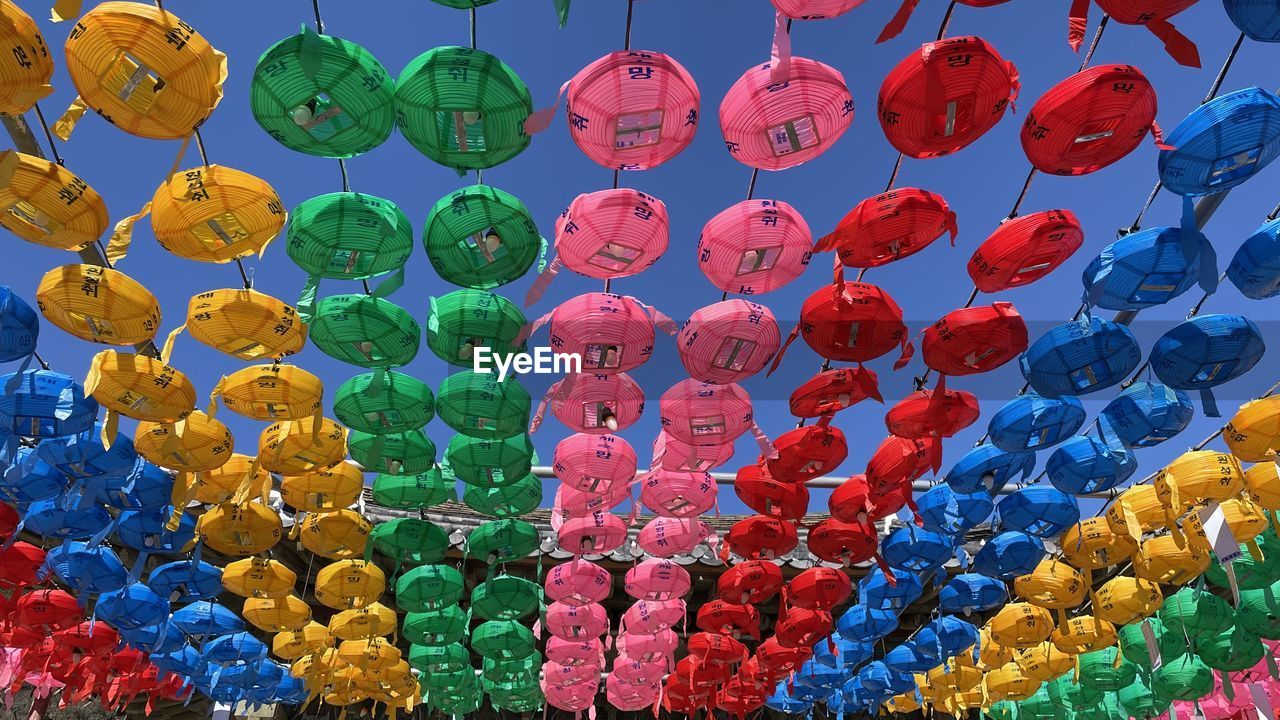 Low angle view of multi colored lanterns hanging against sky