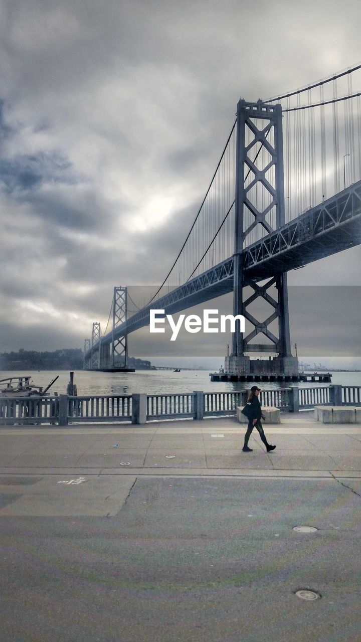 View of suspension bridge against cloudy sky