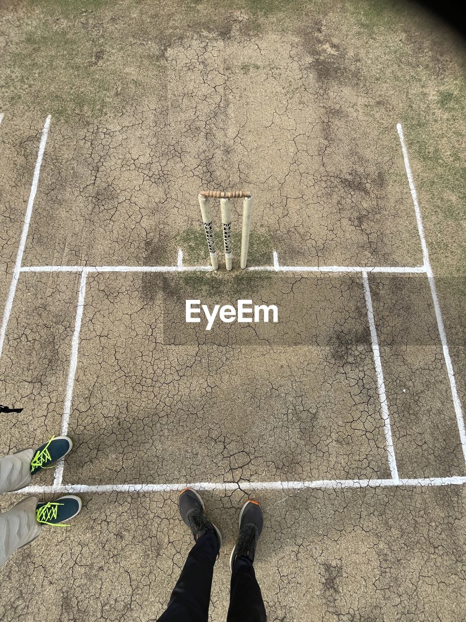 high angle view, sports, low section, day, green, one person, human leg, leisure activity, sunlight, lifestyles, shadow, shoe, wall, directly above, outdoors, nature, flooring, men, standing, footwear, playground, line, net