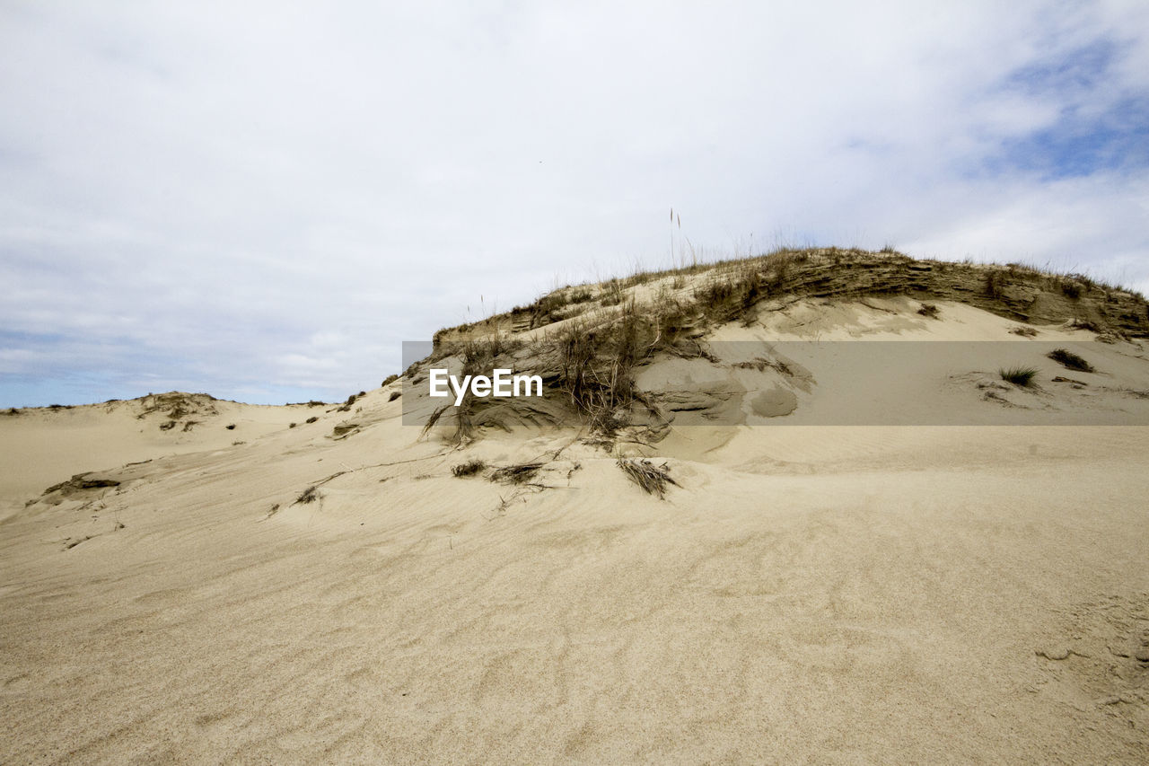 Sand dunes in desert against sky