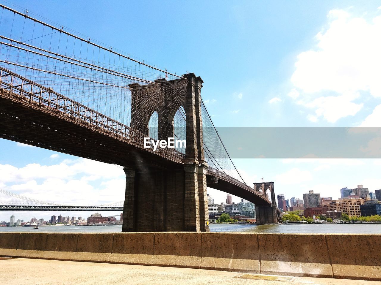 LOW ANGLE VIEW OF SUSPENSION BRIDGE OVER RIVER