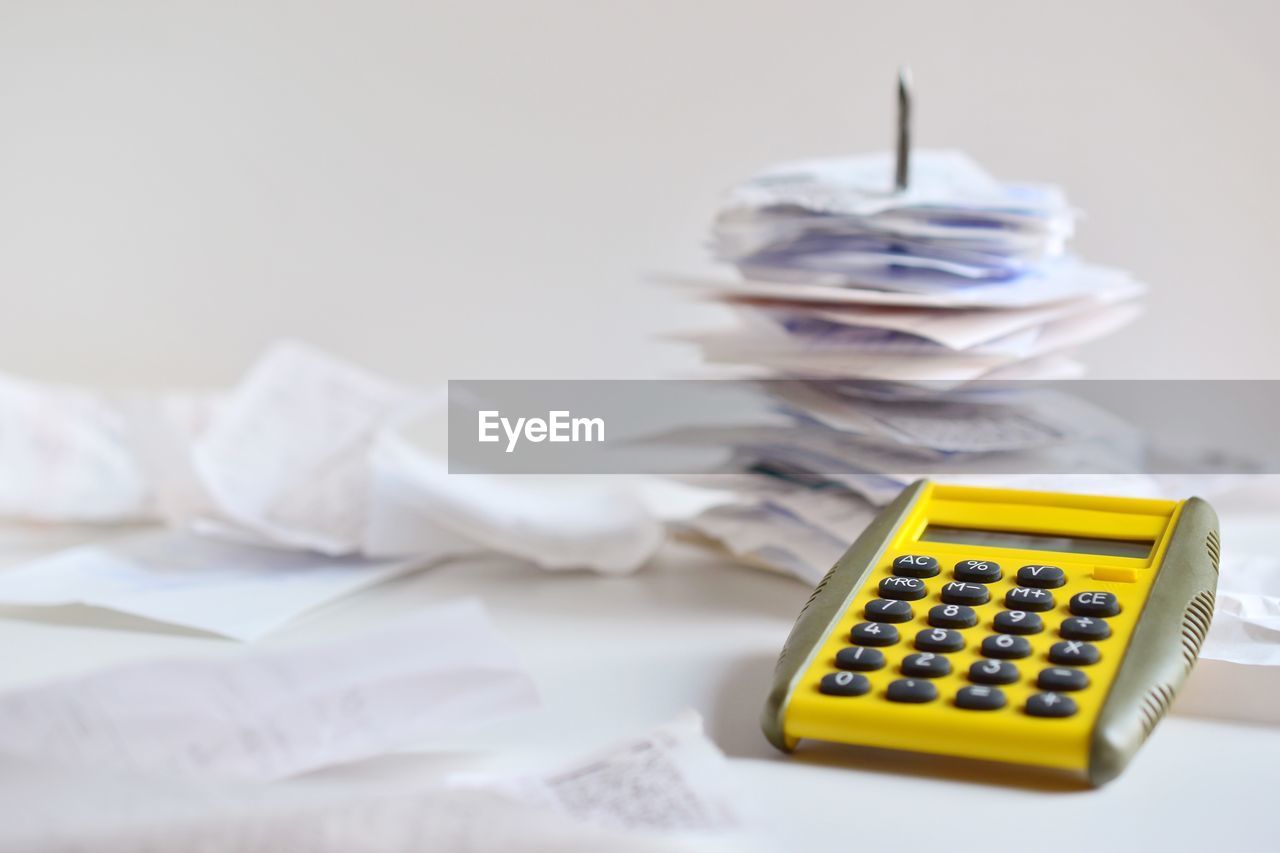 Close-up of bills and calculator on table