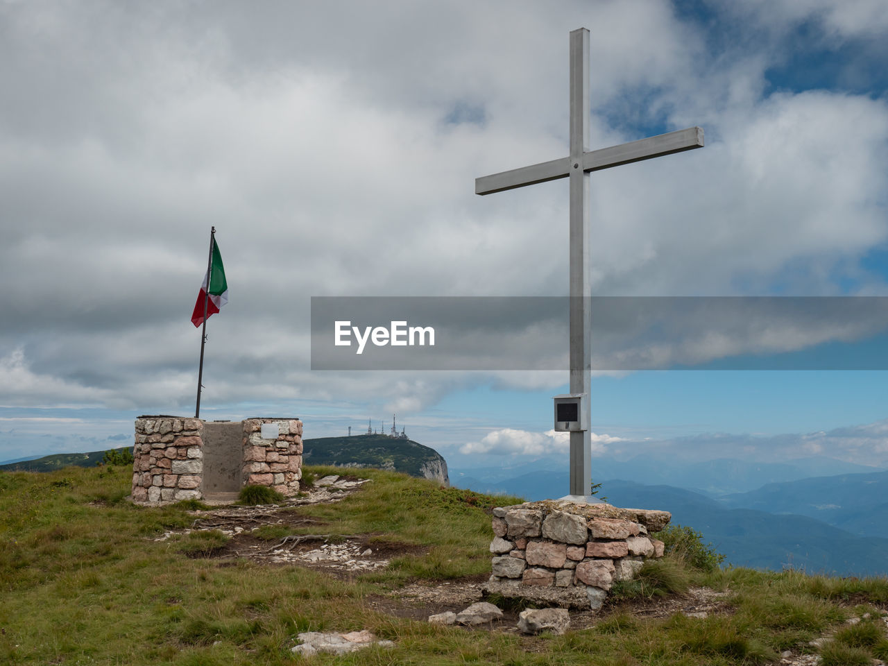 sky, cloud, flag, environment, nature, architecture, built structure, no people, landscape, tower, beauty in nature, cross, day, scenics - nature, mountain, wind, land, sea, grass, outdoors, water, travel destinations, tranquility, building, building exterior, religion, patriotism, travel, overcast, history, tranquil scene, the past, dramatic sky, rock, non-urban scene, beach, coast, cloudscape, belief, storm, idyllic