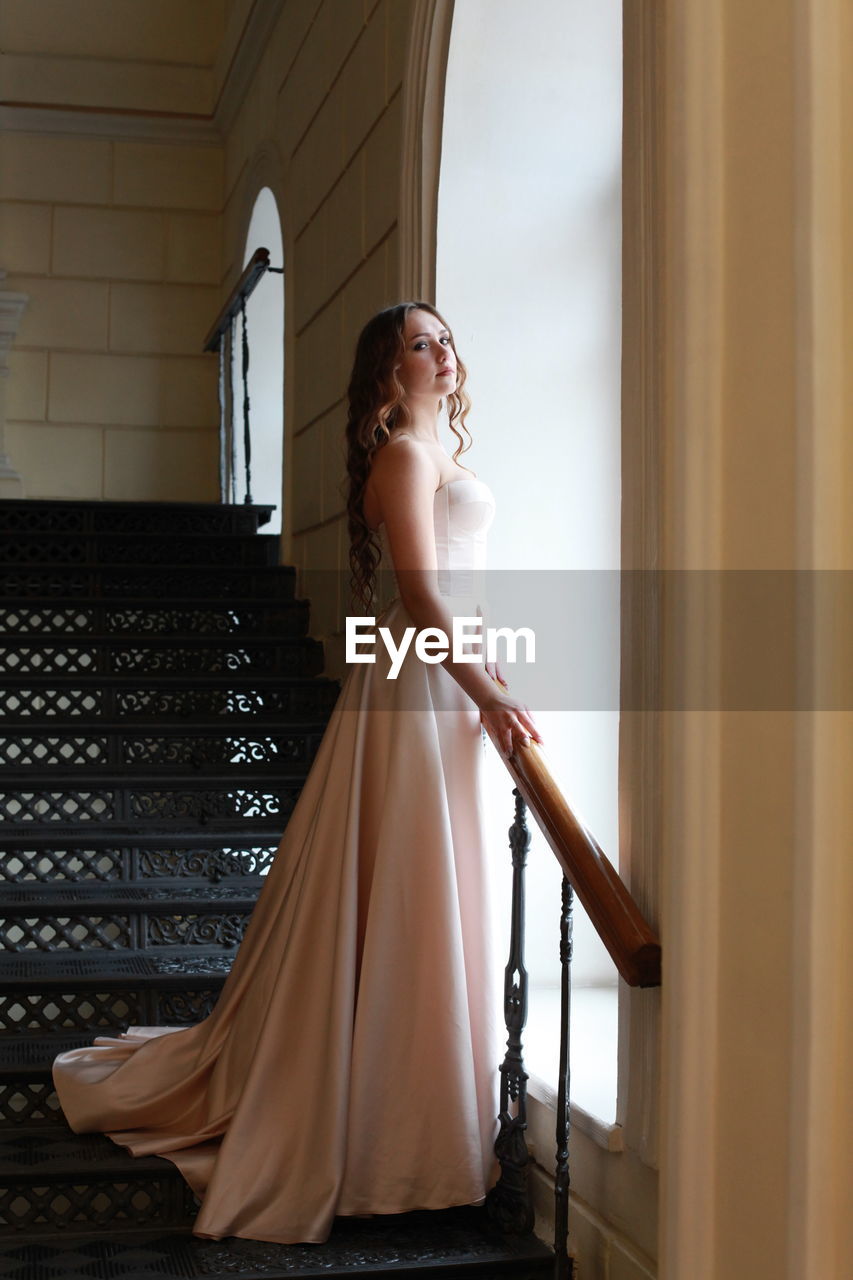 FULL LENGTH OF WOMAN STANDING IN CORRIDOR