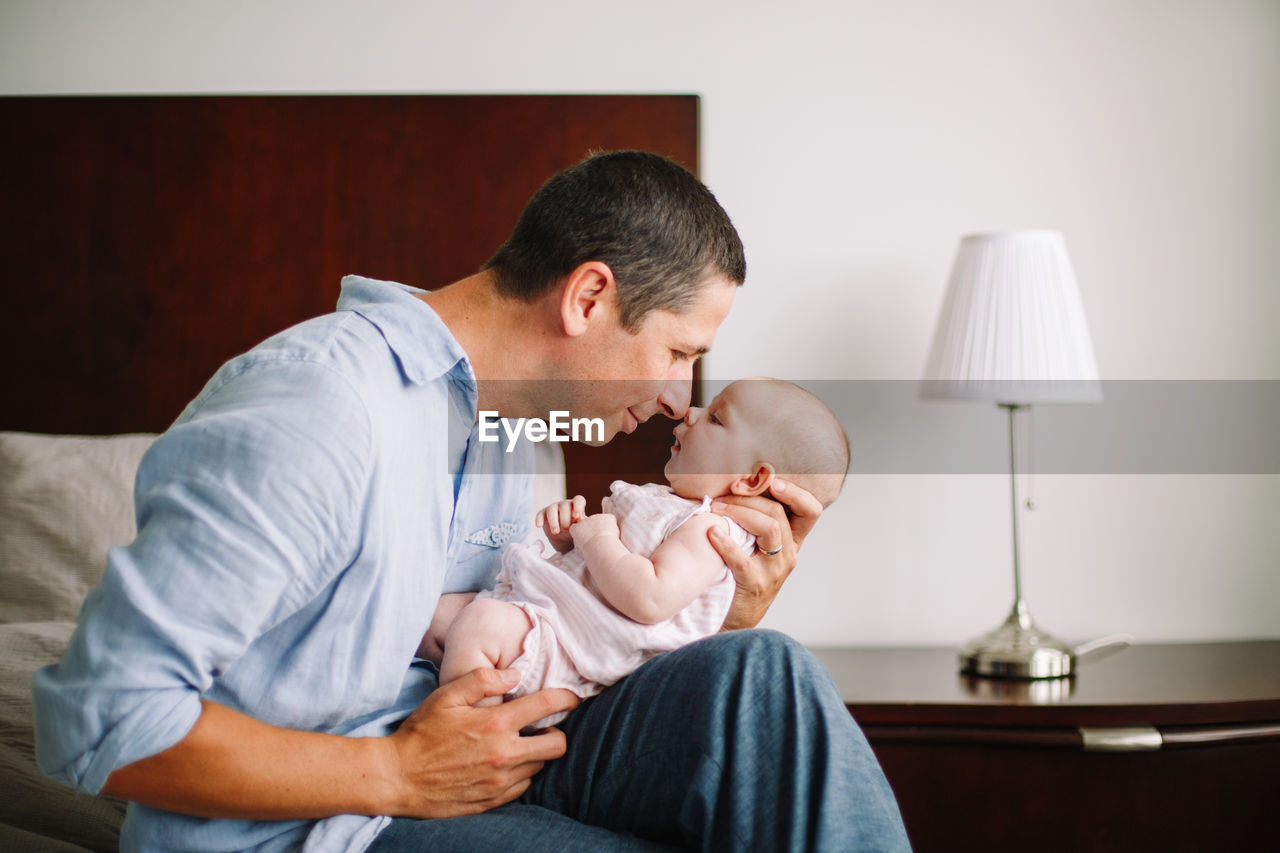 Fathers day holiday. middle age caucasian father hugging and kissing newborn baby. man parent 