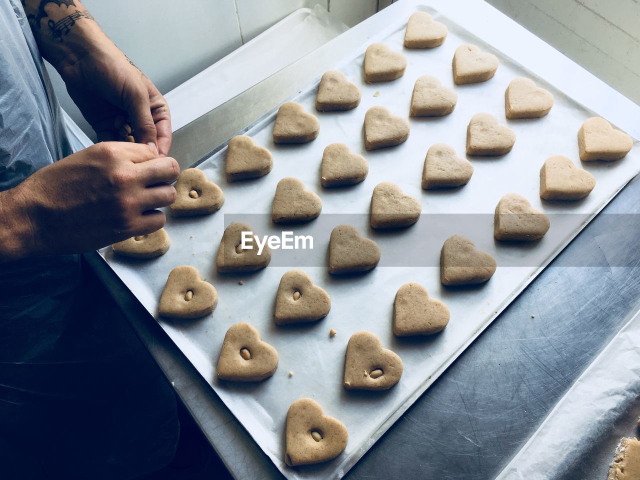 Midsection of male chef preparing heart shape cookies in kitchen