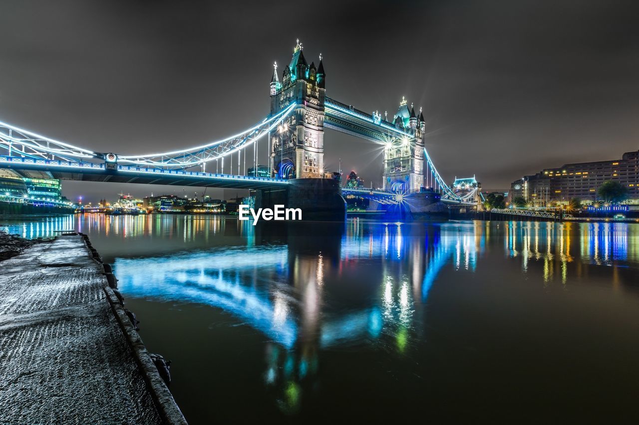 Illuminated tower bridge over thames river in city at night