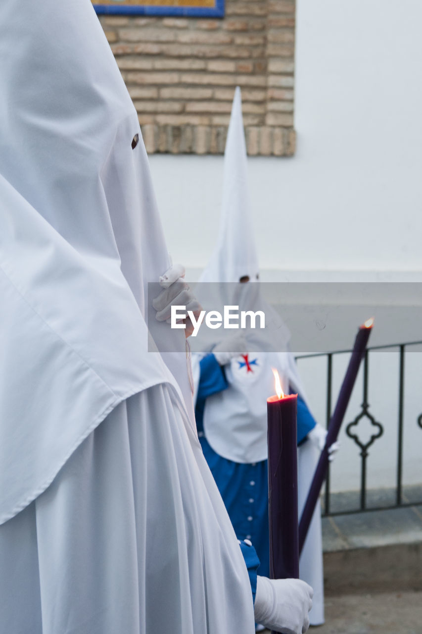 View of people wearing costume standing while holding candle