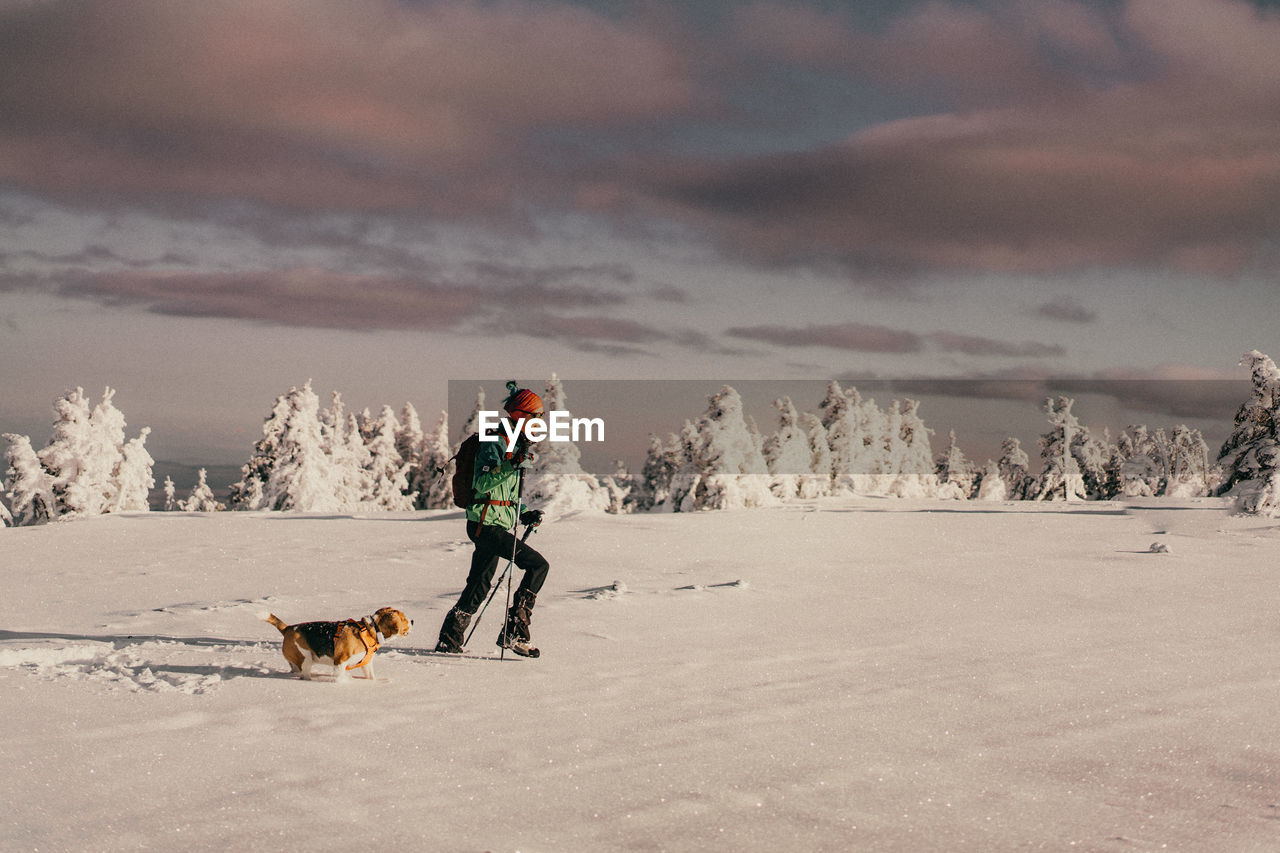 Rear view of woman walking on snow covered landscape