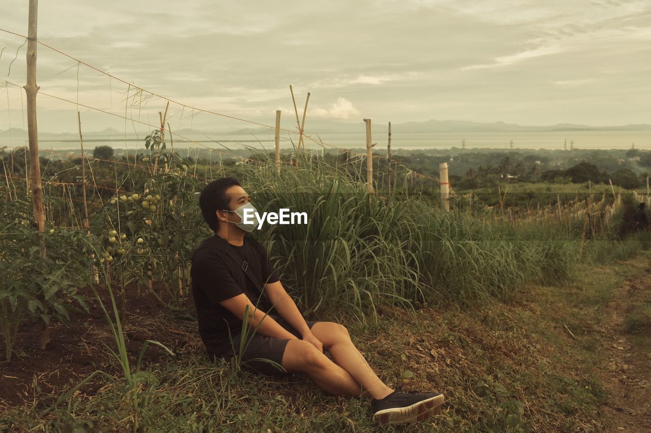 Young man sitting on field