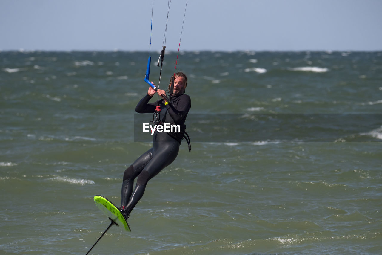 rear view of man jumping in sea