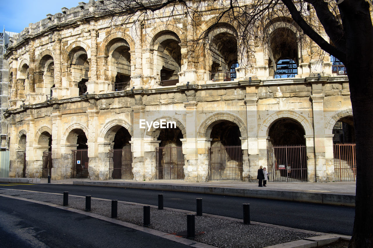 GROUP OF PEOPLE IN FRONT OF OLD BUILDING