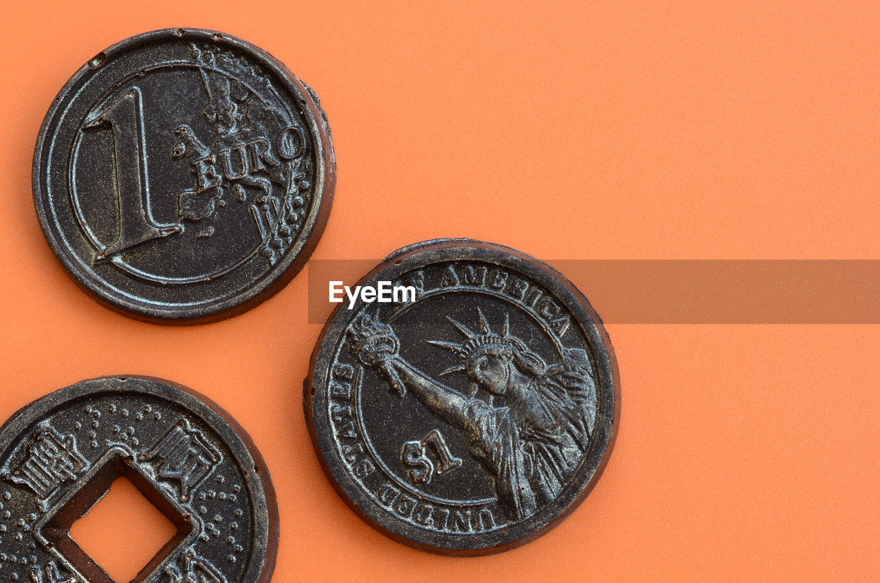 Close-up of coins on orange background