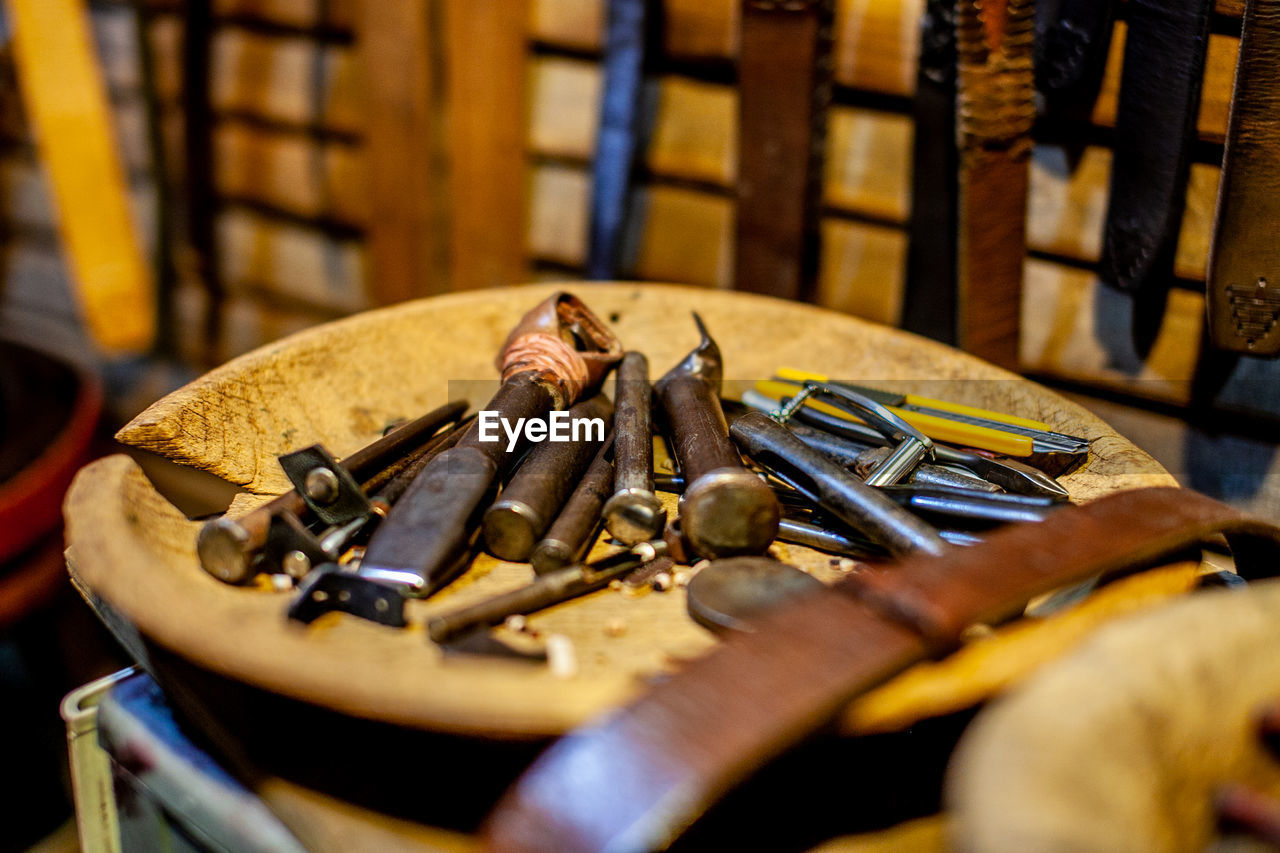 Close-up of rusty work tools on table at workshop