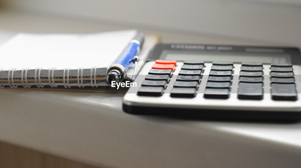 Close-up of calculator and spiral notebooks on table