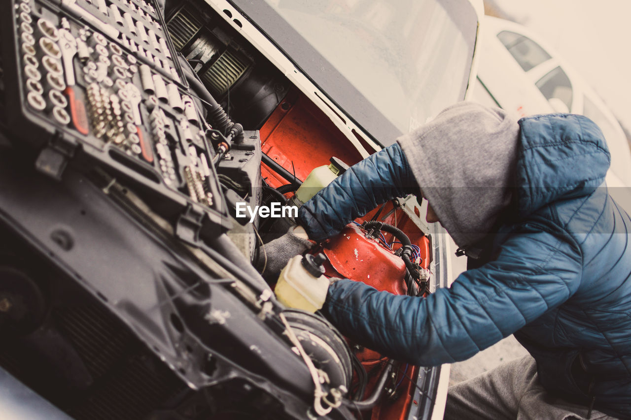 Mechanic repairing car engine at workshop