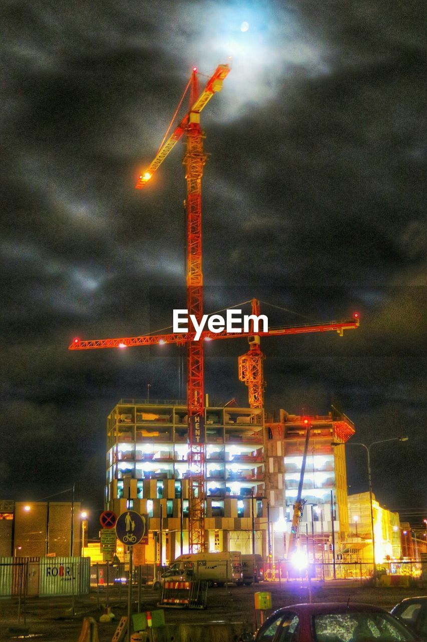 VIEW OF ILLUMINATED CITYSCAPE AGAINST CLOUDY SKY