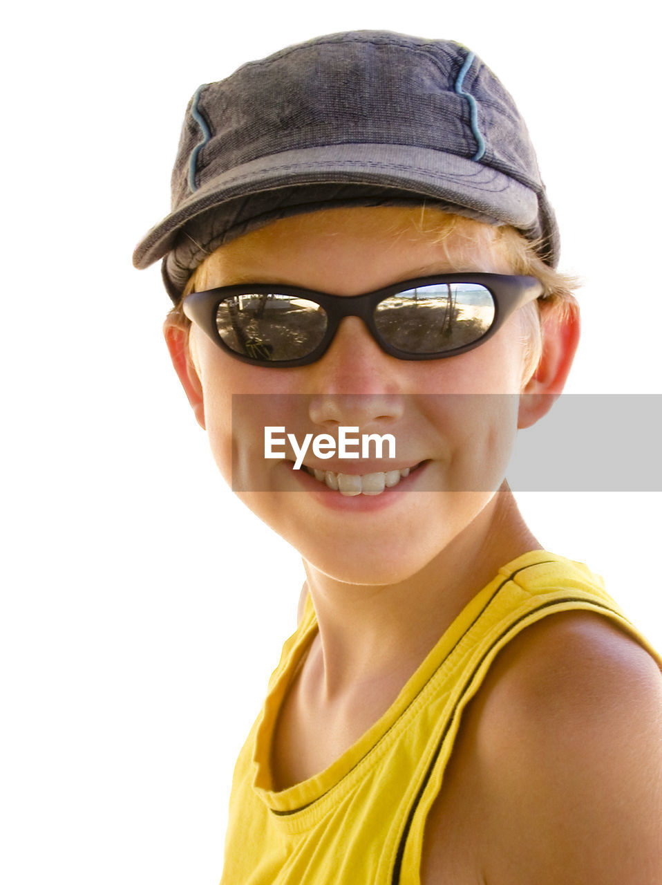 Close-up portrait of smiling boy wearing sunglasses and cap on sunny day
