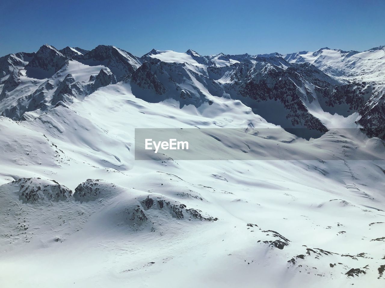 Scenic view of snow covered mountains against sky