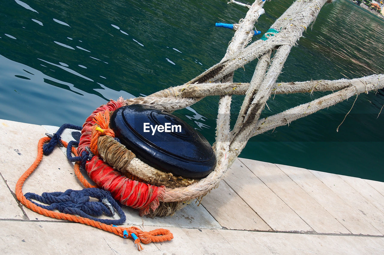 Ropes tied up on bollard at harbor