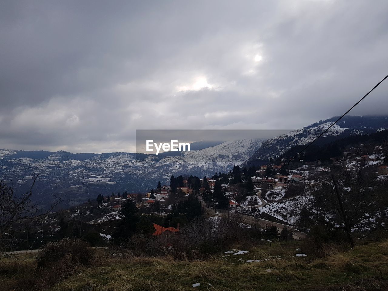 Aerial view of townscape and mountains against sky