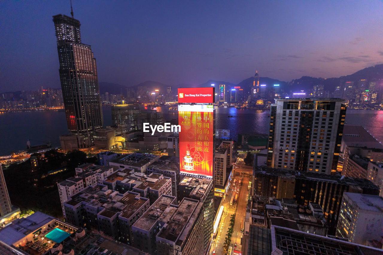 HIGH ANGLE VIEW OF ILLUMINATED BUILDINGS AT NIGHT