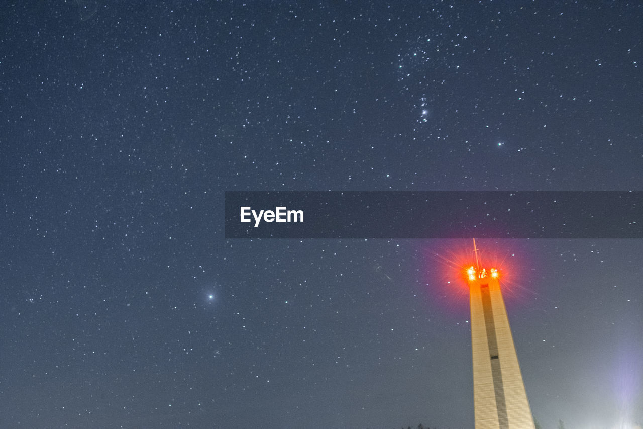 LOW ANGLE VIEW OF ILLUMINATED CLOCK TOWER AGAINST SKY