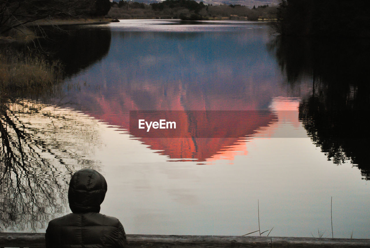 Rear view of man looking at lake with mt. fuji reflection