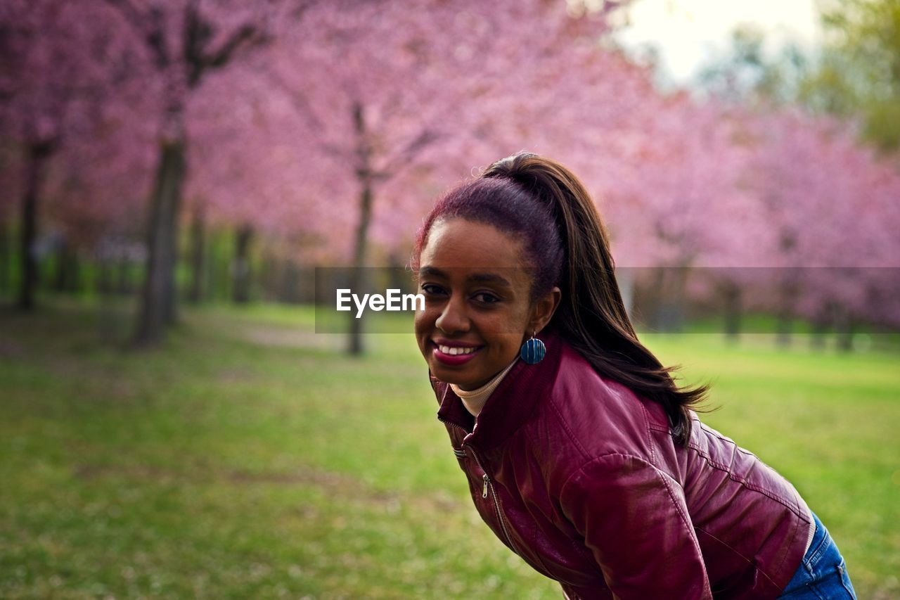 Portrait of smiling young woman on pink land
