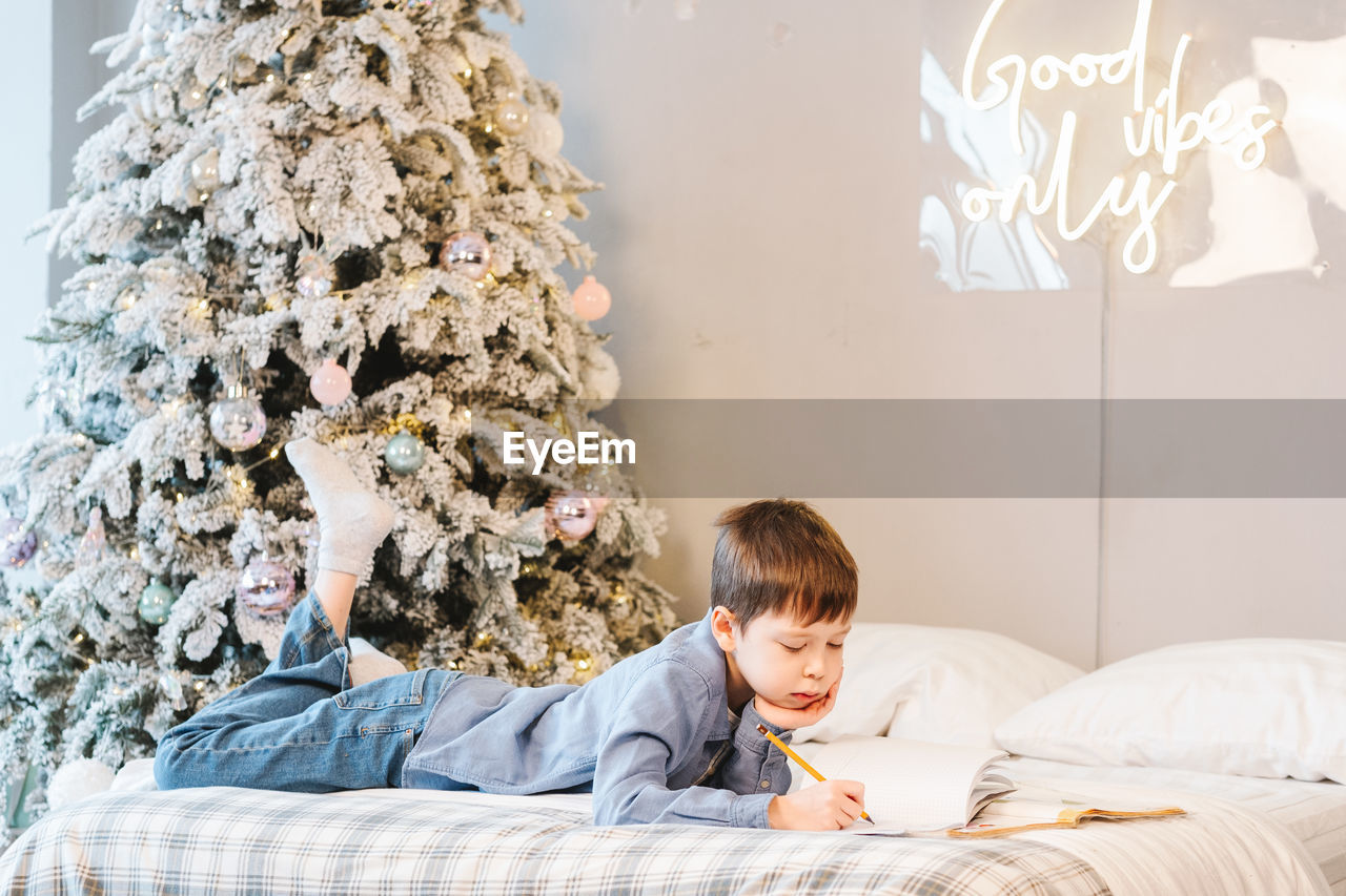 portrait of boy playing with teddy bear at home