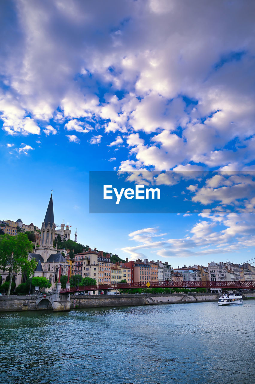 RIVER AMIDST BUILDINGS AGAINST SKY