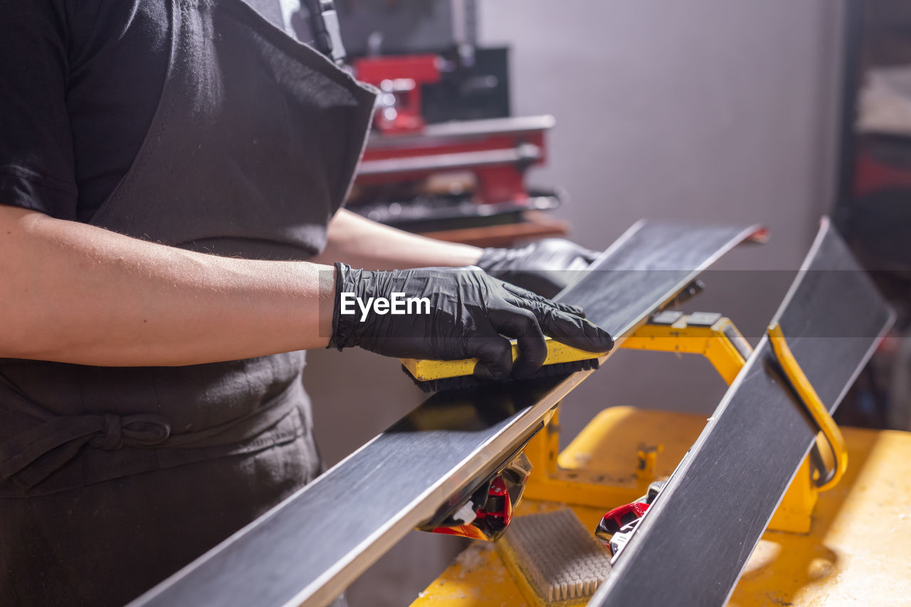 MIDSECTION OF MAN WORKING ON ESCALATOR