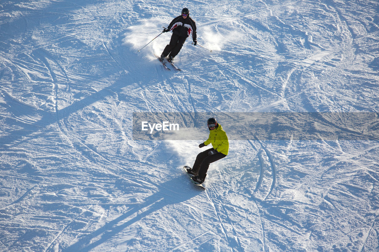 High angle view of people skiing and snowboarding on snow