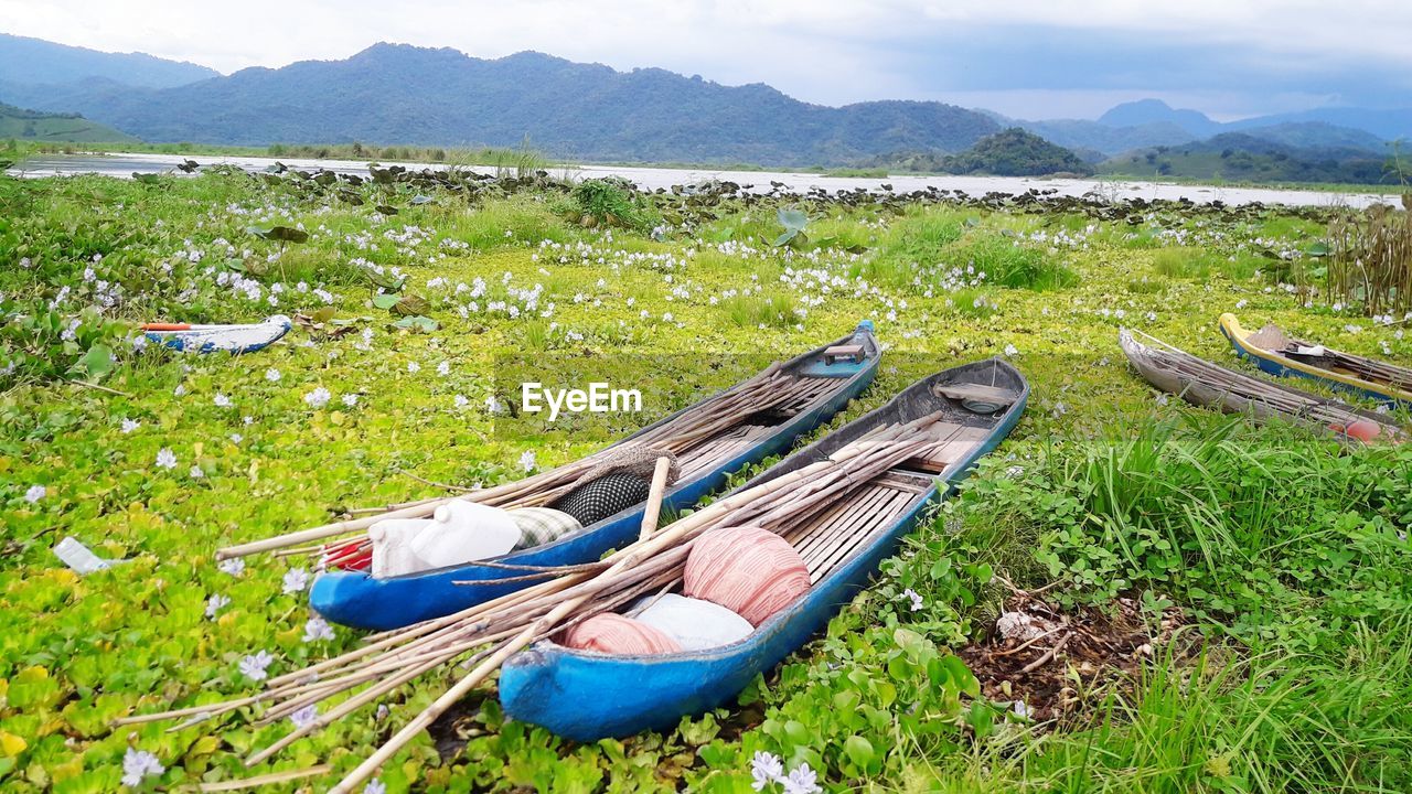 Boats moored on lake against sky