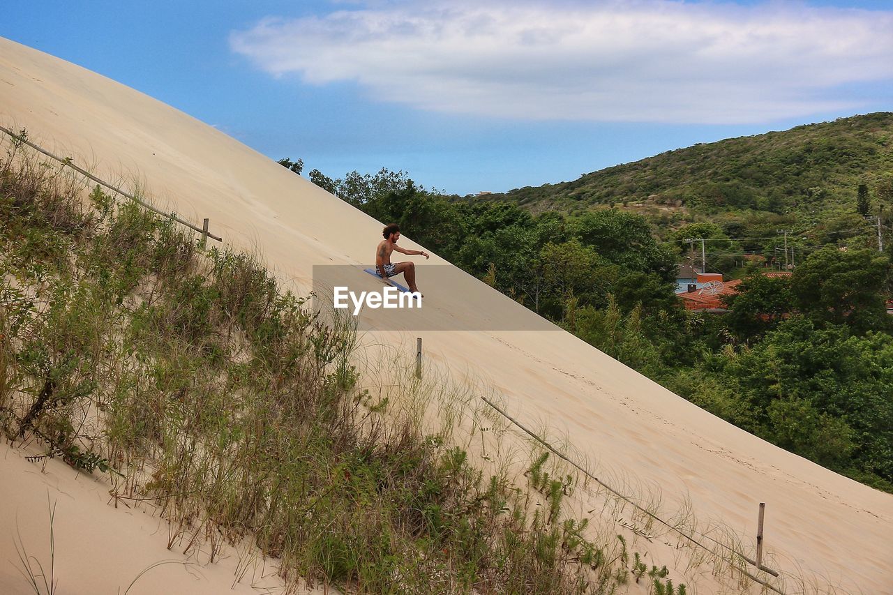 PEOPLE ON LAND AGAINST SKY