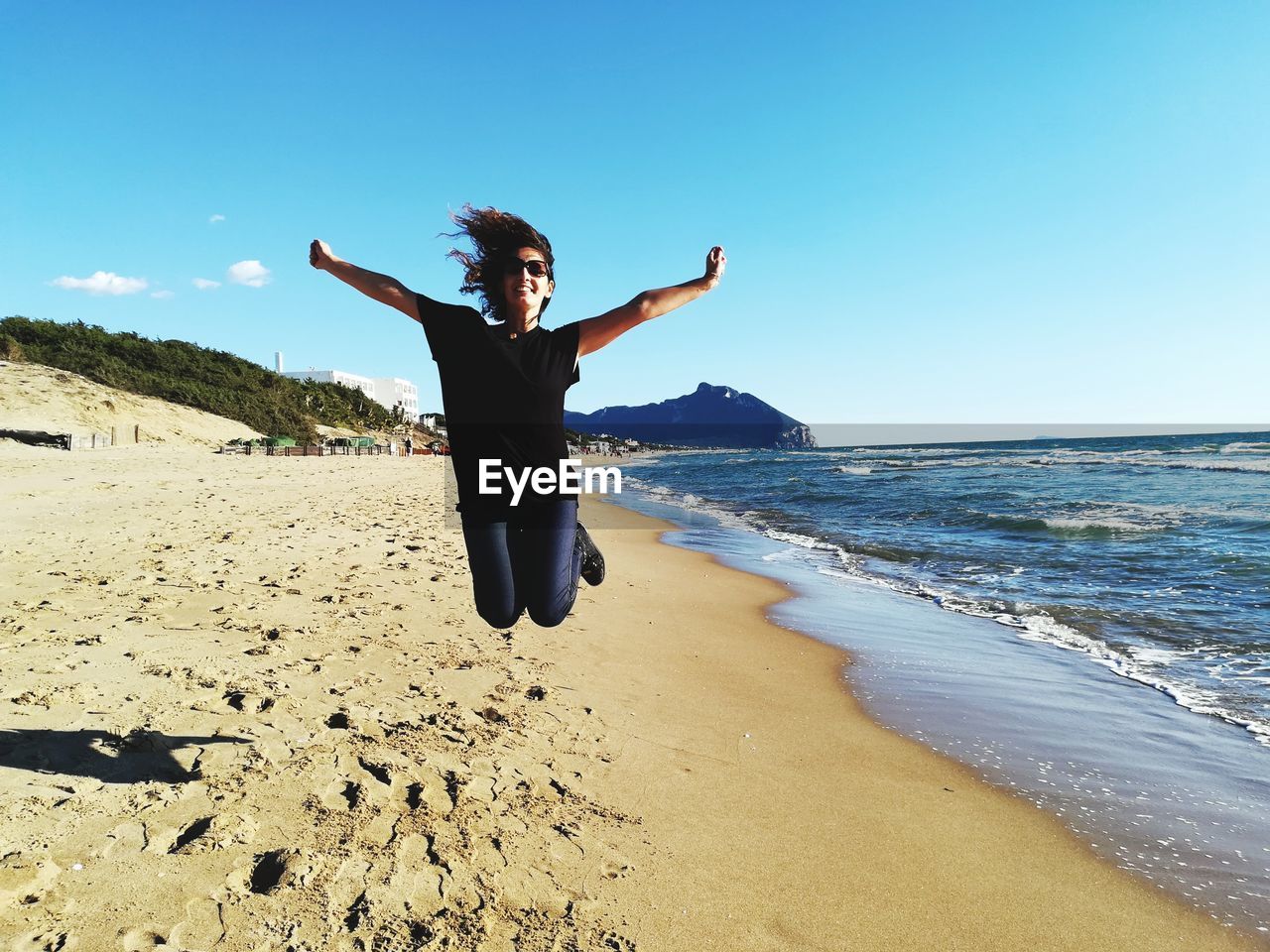 Full length of woman jumping at beach