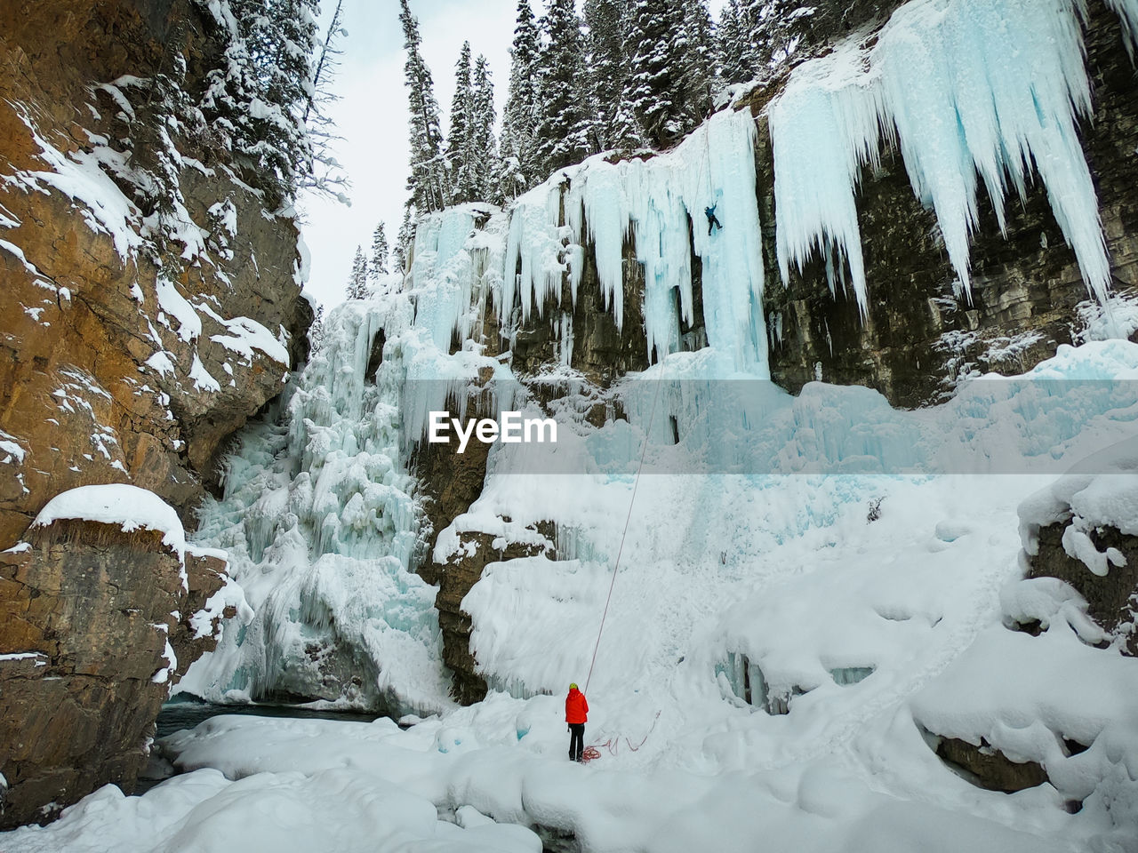 Male ice-climber scaling a massive and treacherous ice wall. 