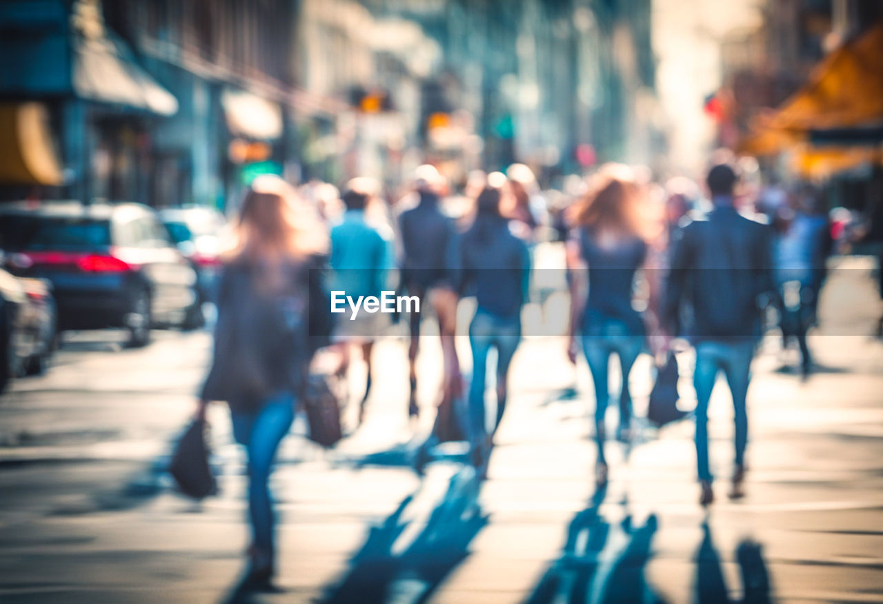 Blurred people walking in the city streets at the rush hour. time lapse motion effect. sunlight