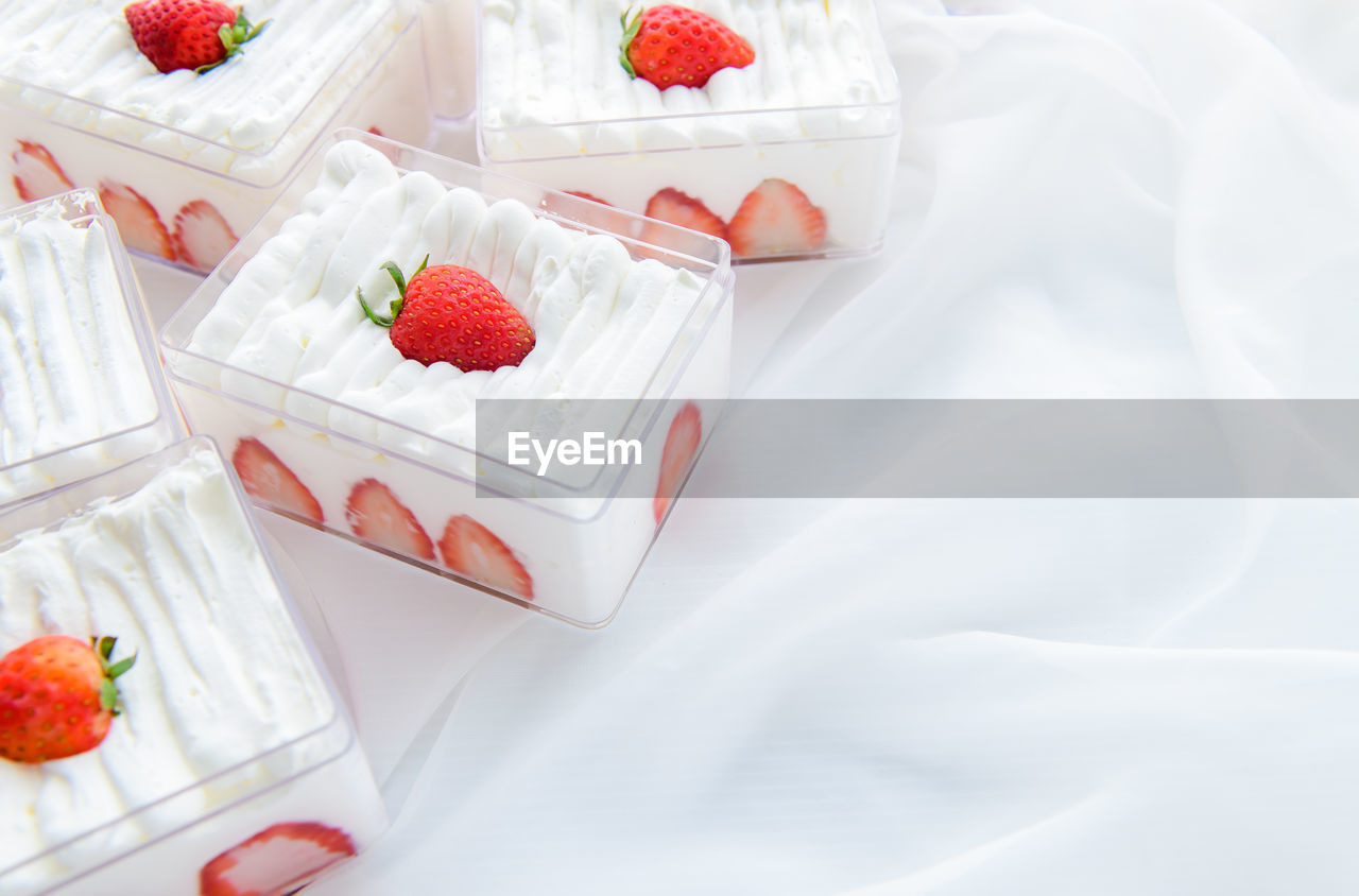 Strawberry shortcake in plastic box on with cloth background and copy space,