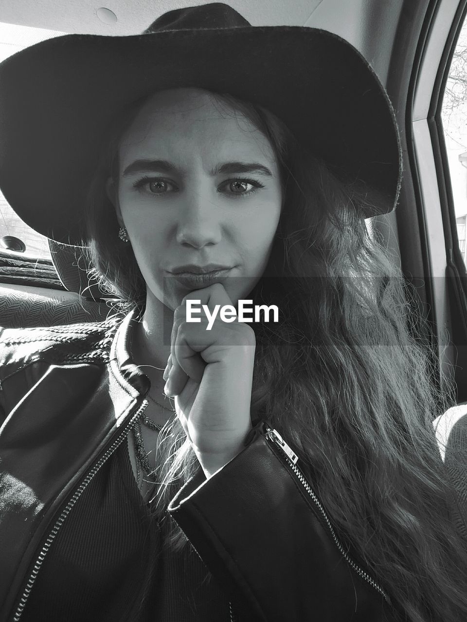 Portrait of woman wearing hat traveling in car