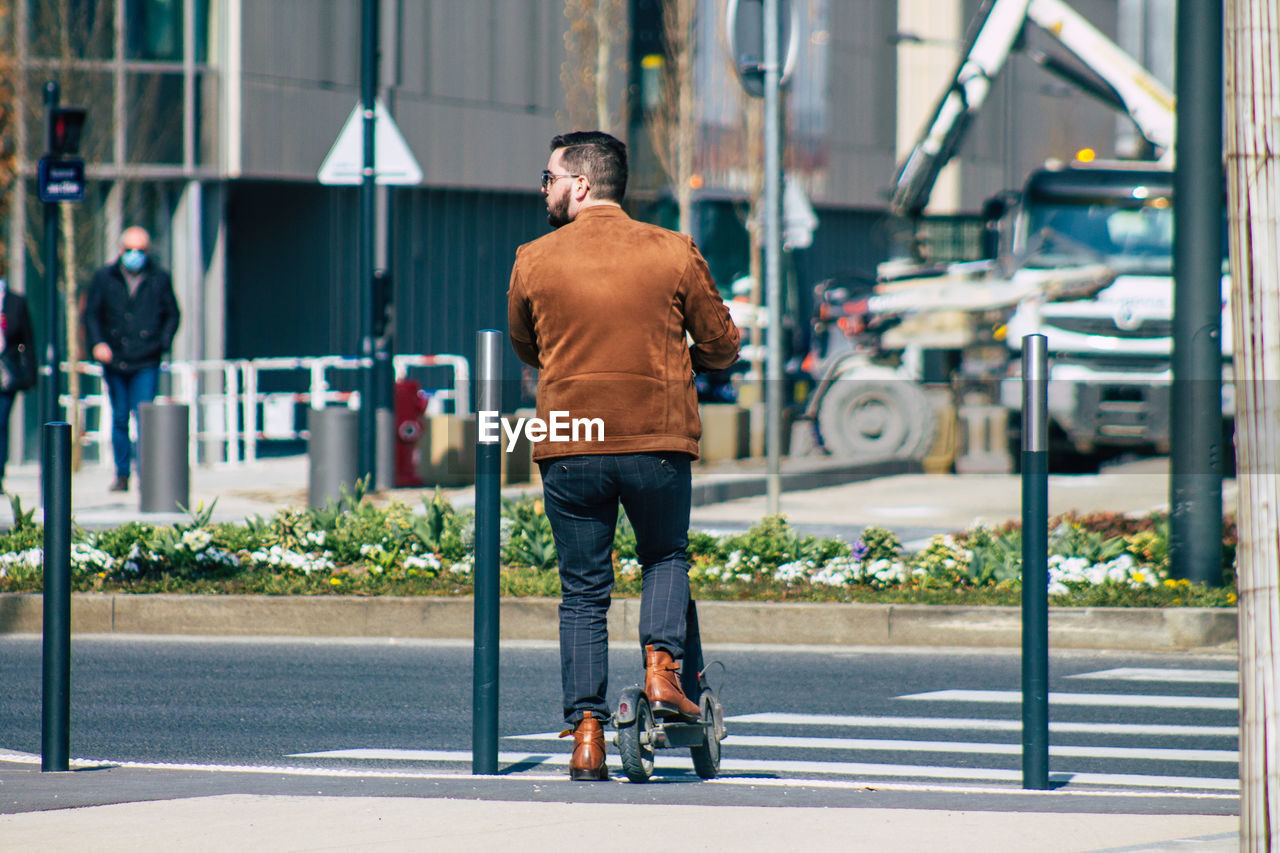 FULL LENGTH REAR VIEW OF MAN ON STREET