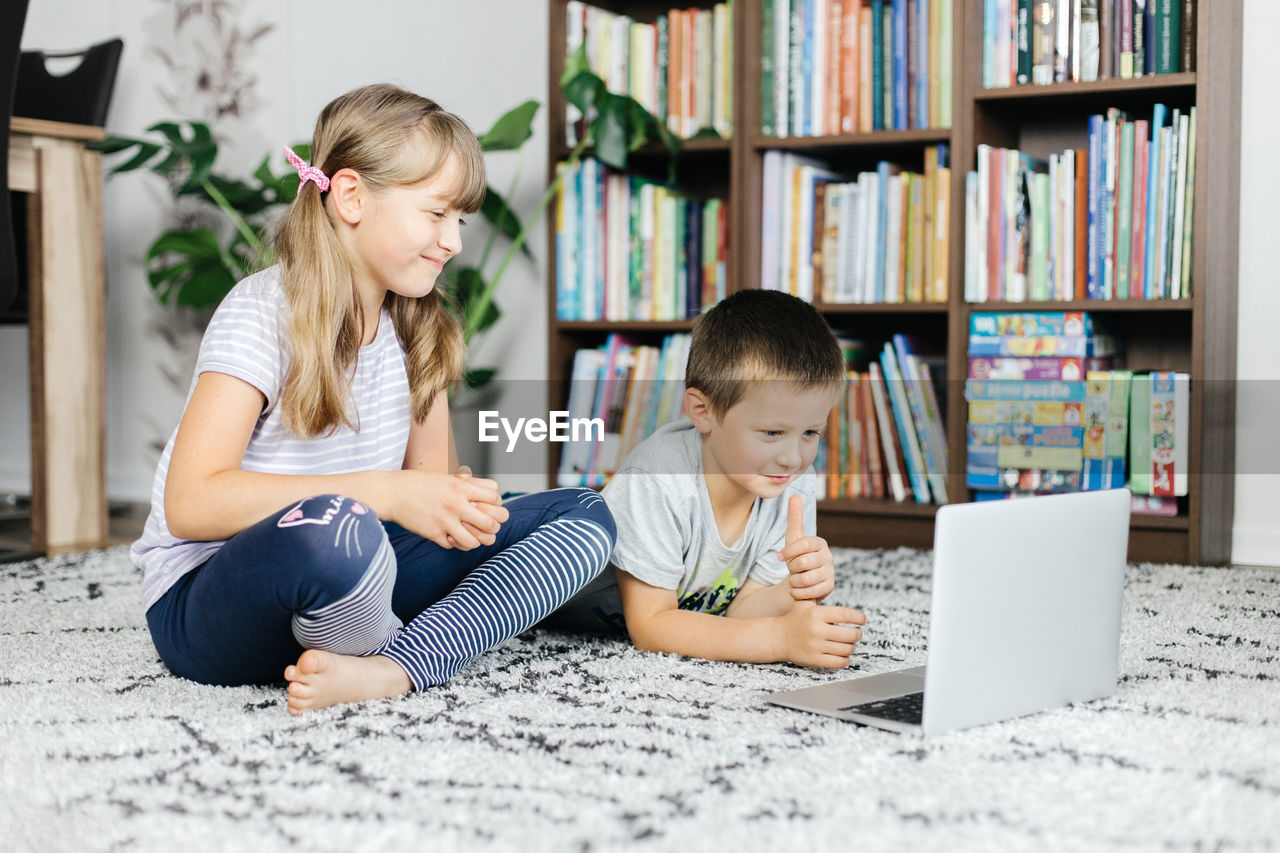 Children watch lessons through a laptop and make online calls.social media and the use of technology