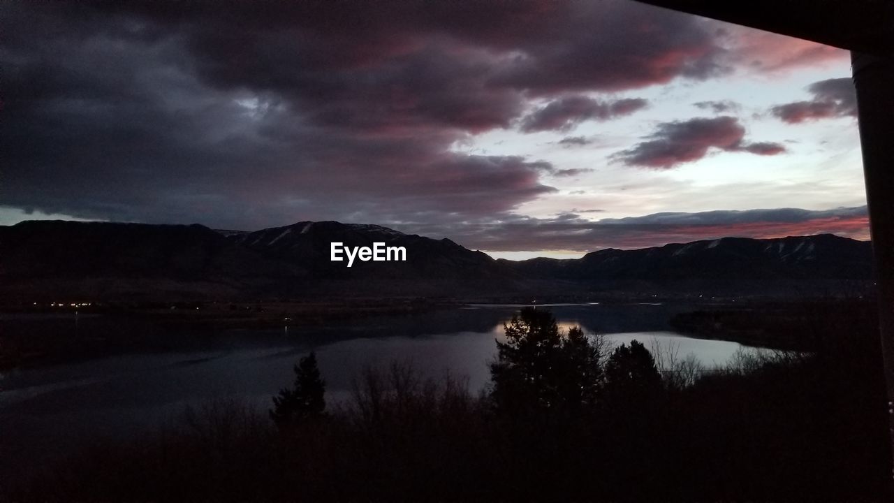 SCENIC VIEW OF LAKE AND MOUNTAINS DURING SUNSET