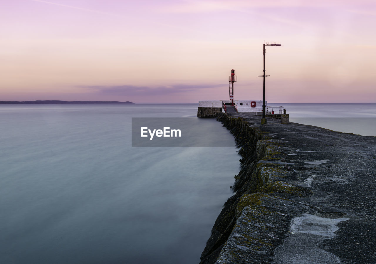 Scenic view of sea and pier against sky during sunset