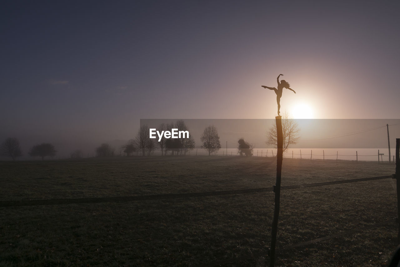 SCENIC VIEW OF SILHOUETTE FIELD AGAINST SKY DURING SUNSET