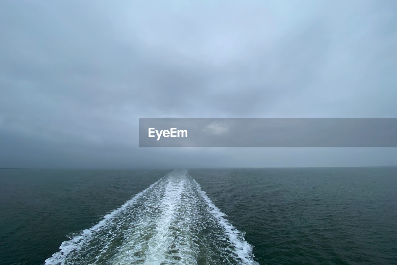 Scenic view of sea against sky with trace of a ferryboat