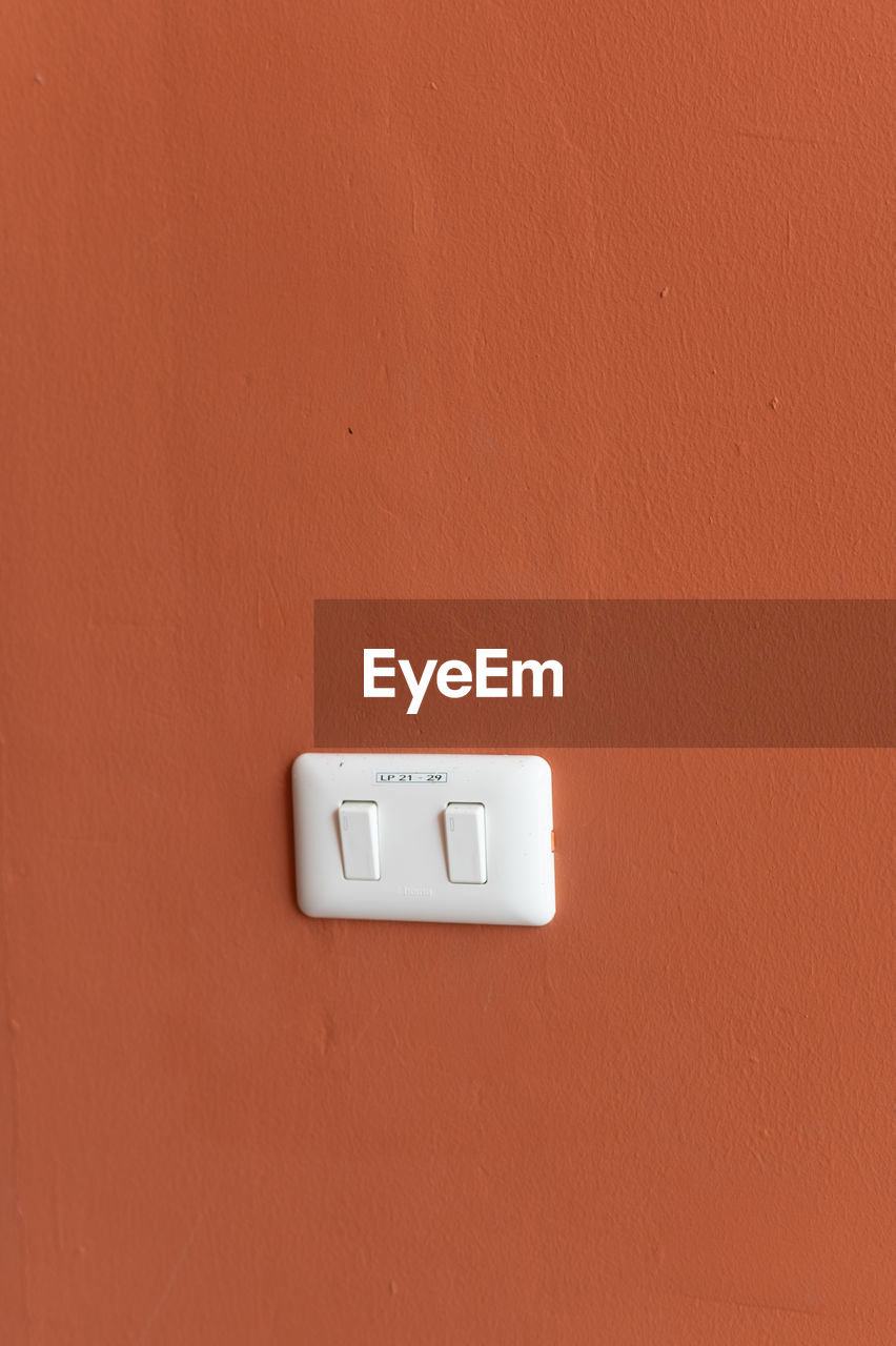 electricity, wall - building feature, light switch, power supply, technology, no people, control, power generation, orange color, cable, switch, indoors, close-up, orange, copy space, power plugs and sockets, built structure, outlet, electric plug