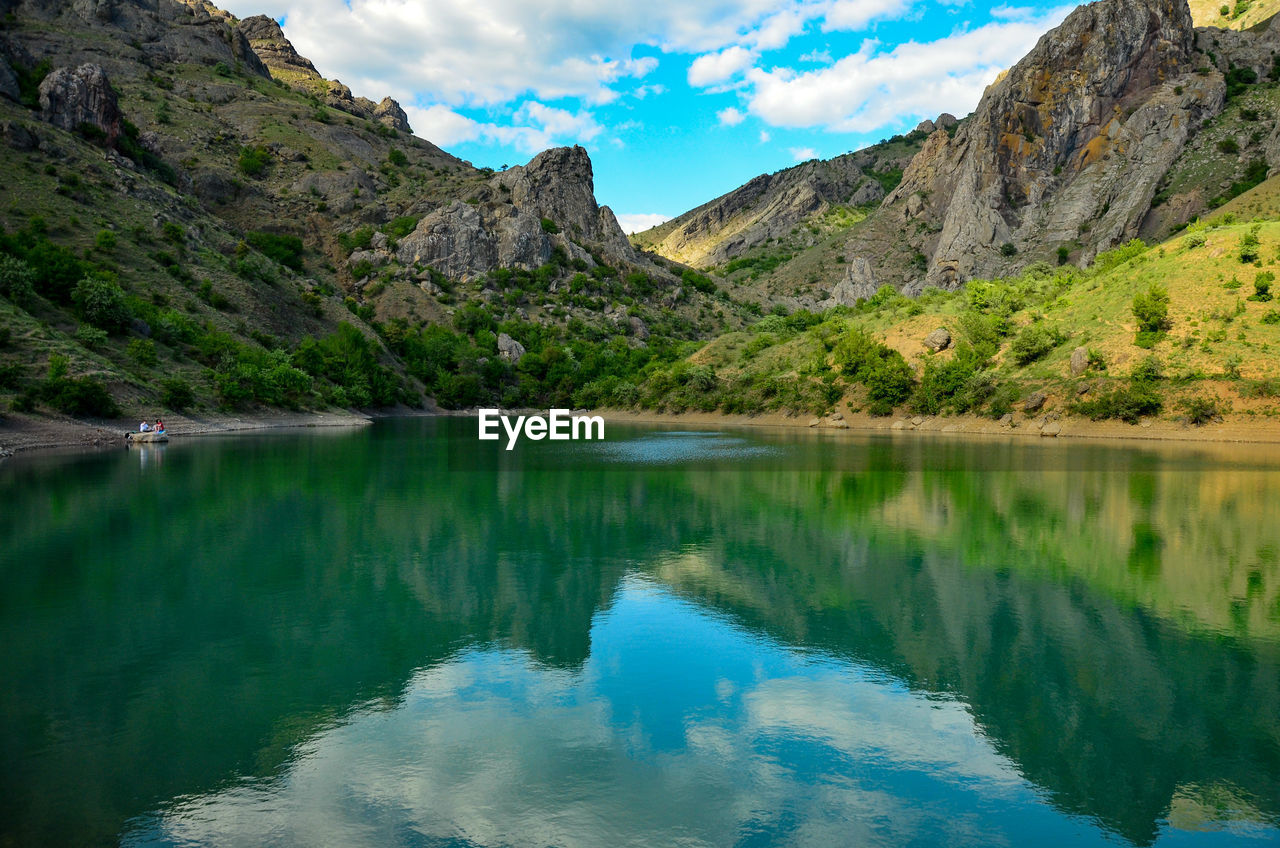 Scenic view of lake and mountains against sky